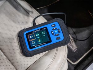 Autophix DM5600 diagnostic tool in use in a car.