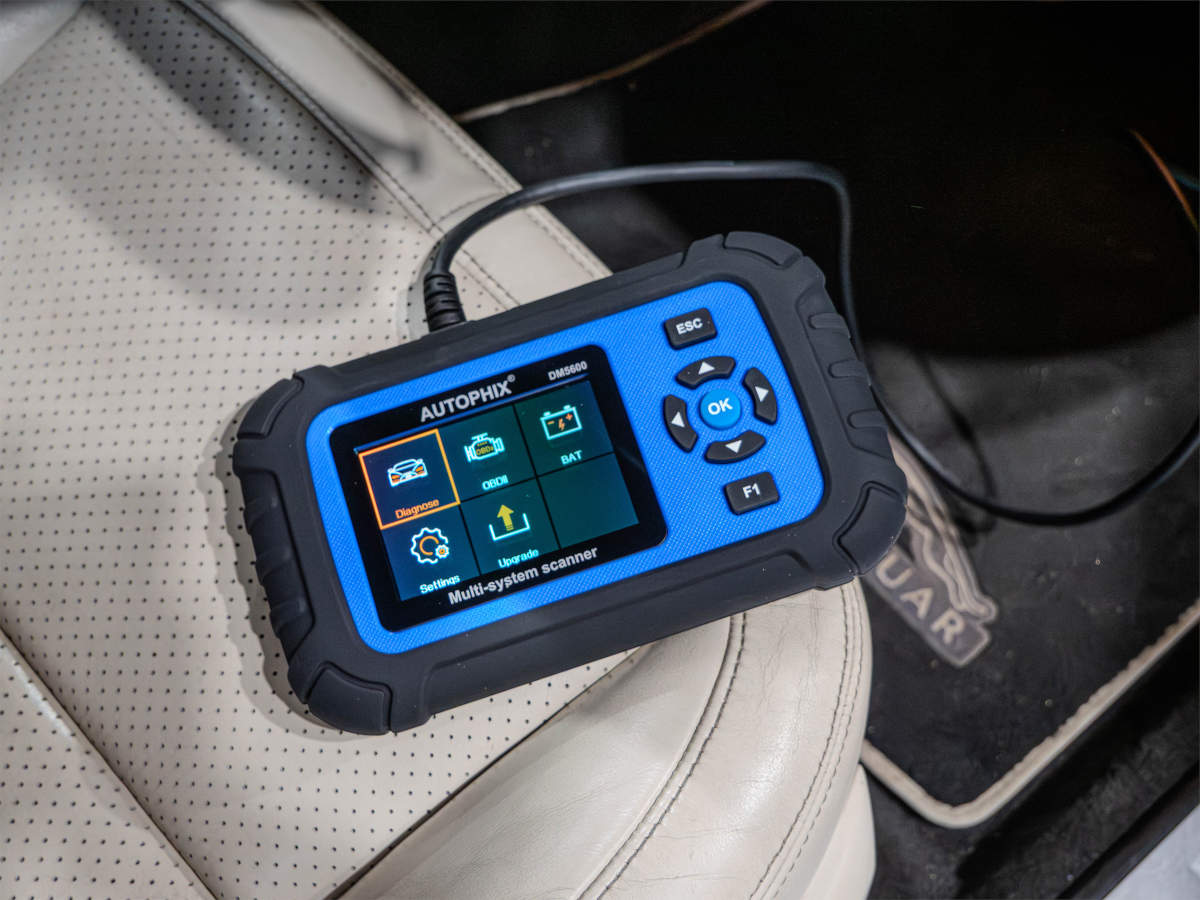 Autophix DM5600 diagnostic tool in use in a car.